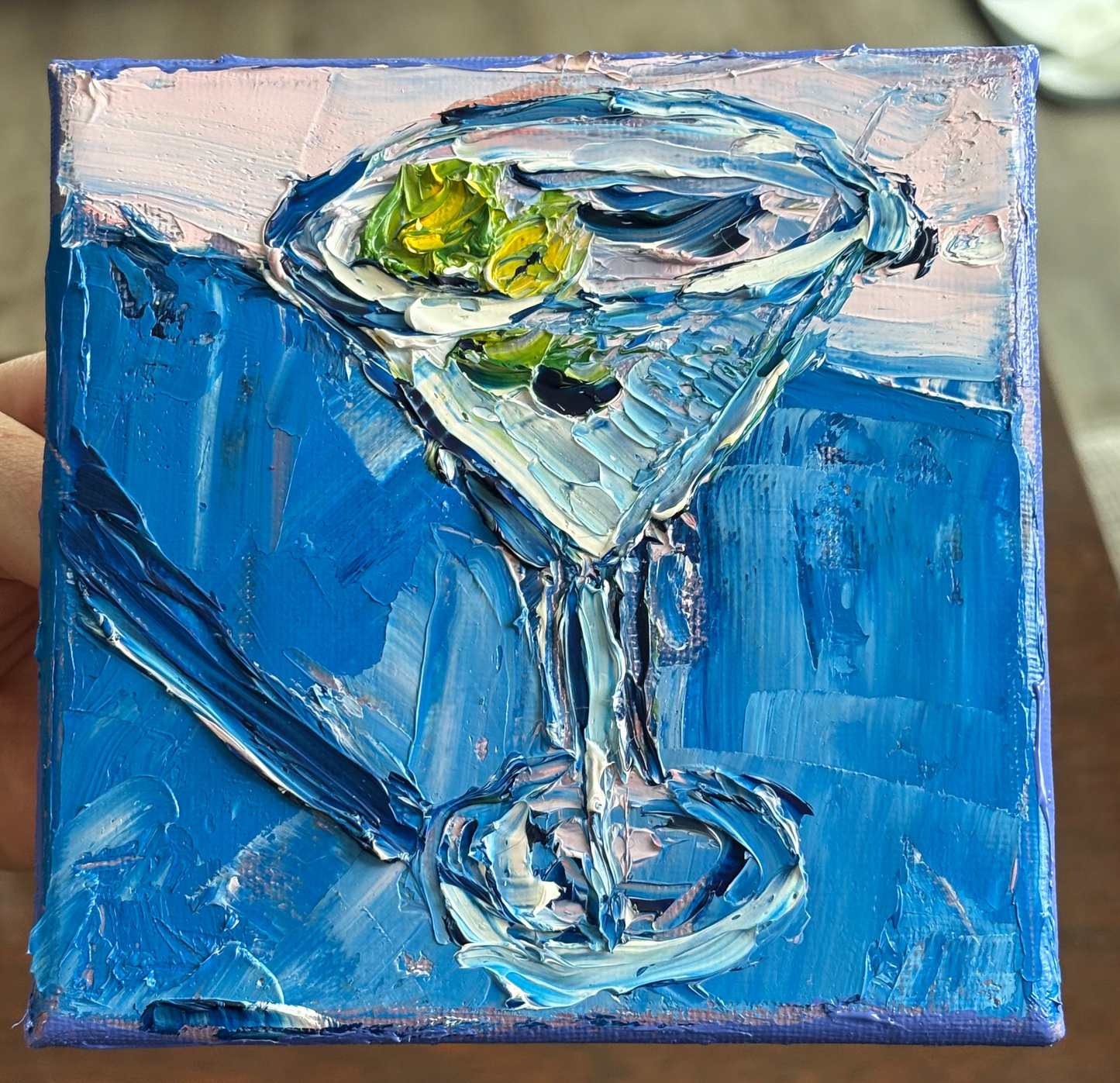 Painting of a martini glass with a blue background
